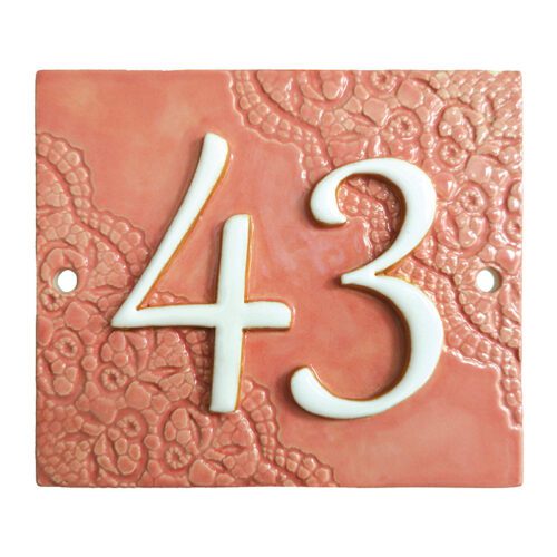 Handgemaakt keramisch huisnummerbord roze, nummer 43. Diagonaal gedecoreerd met kant.
