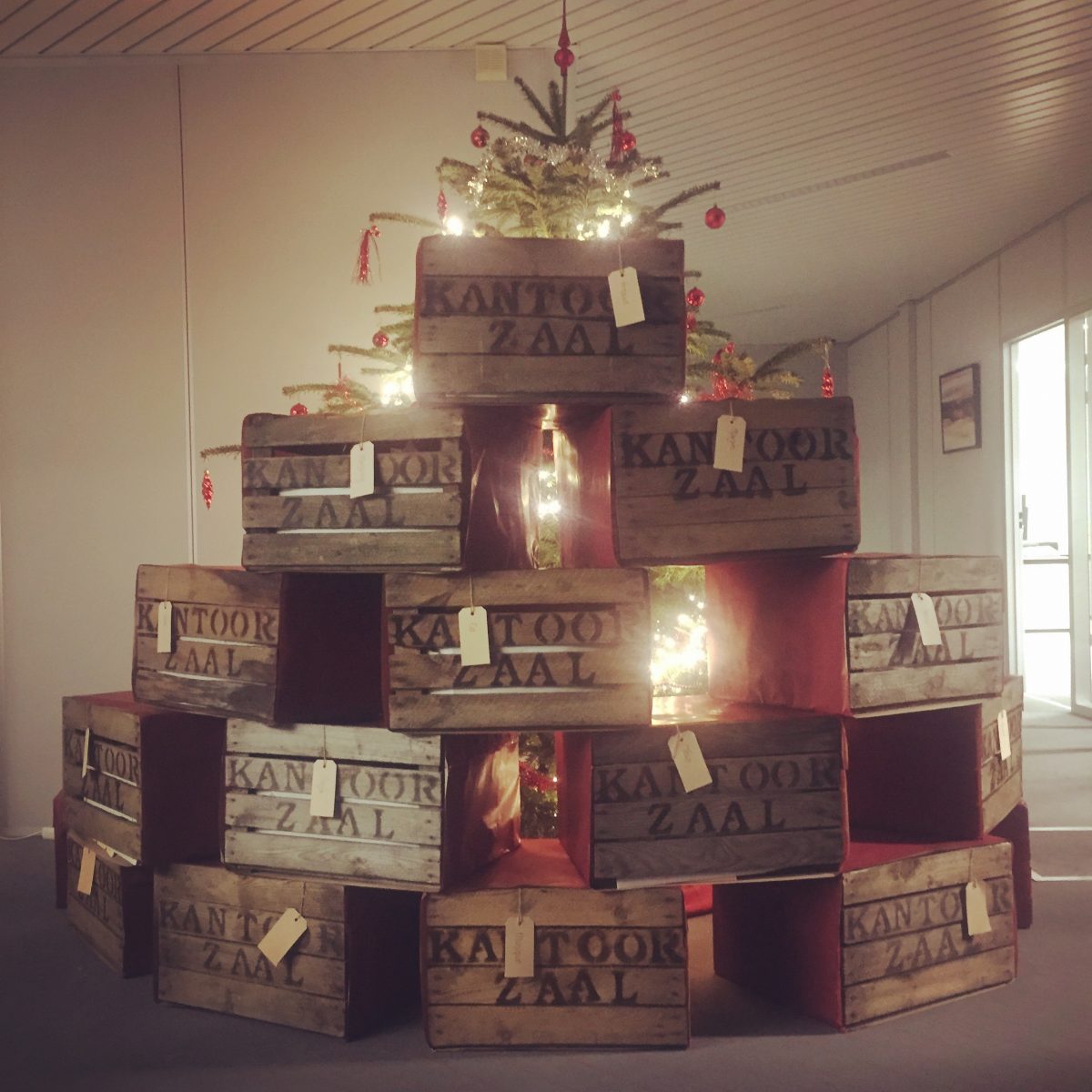 kantoor zaal kerstboom van houten kisten met bedrijfsnaam origineel kerstpakket liefslabel